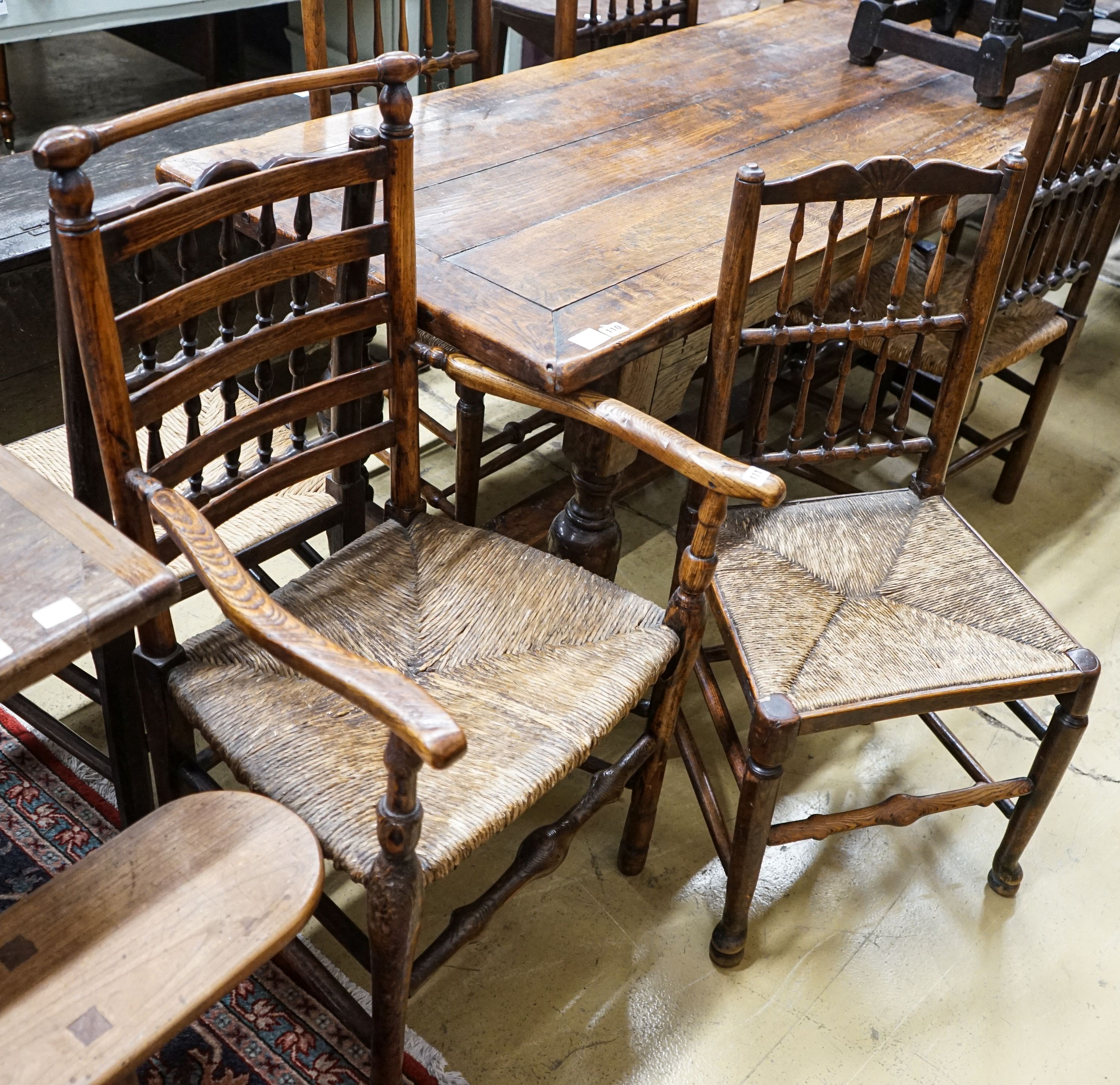 A harlequin set of five oak, elm and beech spindle back chairs, with rush seats and a similar ladderback carver